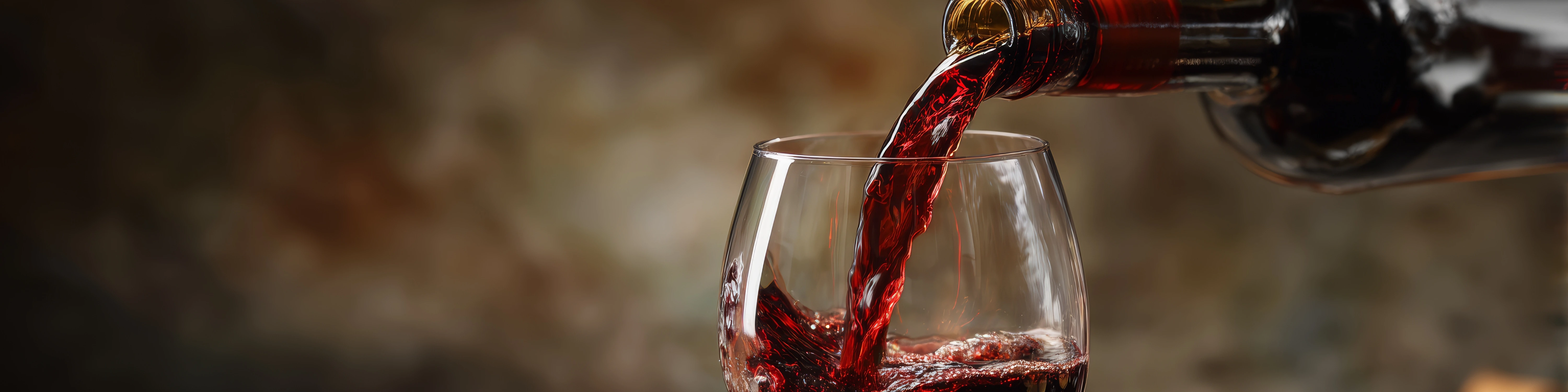 Glas Rotwein wird aus Flasche eingeschenkt, ideal für gemütliche Weinabende