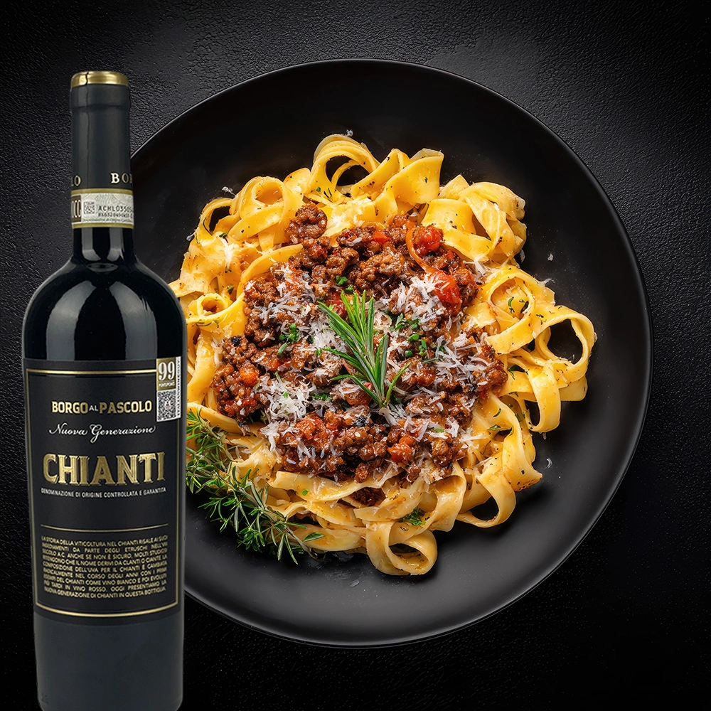 Flasche Borgo al Pascolo Chianti Rotwein neben einem Teller Pasta mit Tomatensauce auf einem festlich gedeckten Tisch mit Kerzenlicht und stimmungsvoller Abendatmosphäre.