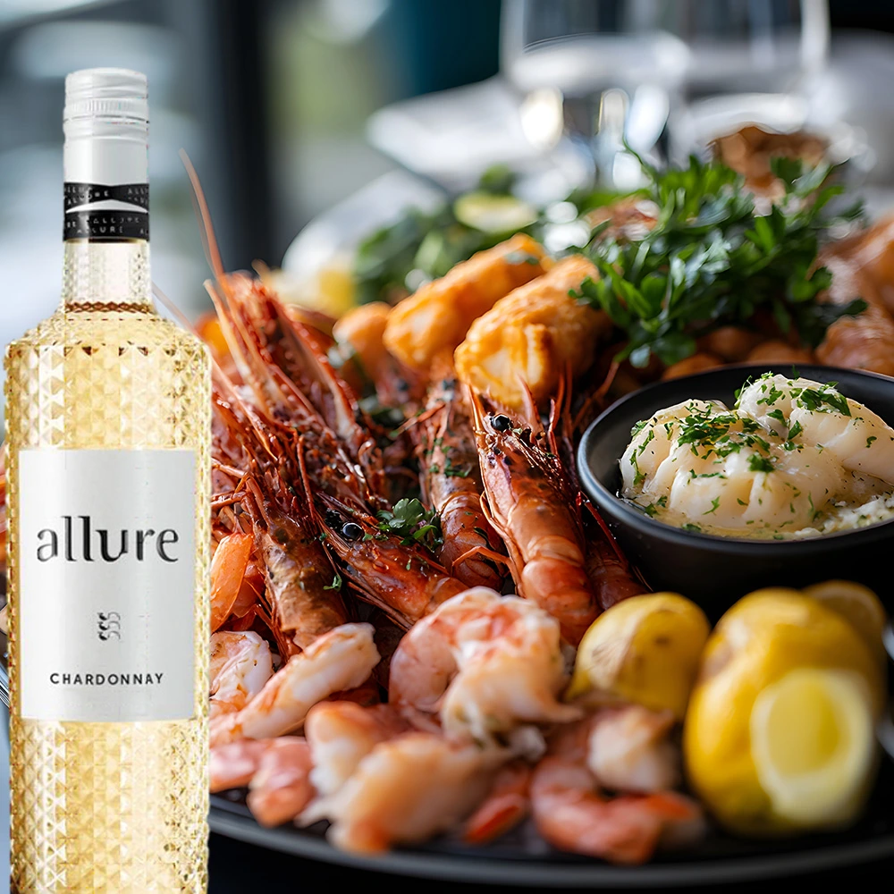 Einzelne Flasche Allure Chardonnay neben einem Teller mit frischen Meeresfrüchten, elegant angerichtet