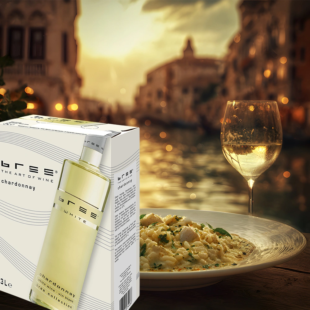 Bree Chardonnay 3,0 Liter Bag-in-Box auf einem stilvoll gedeckten Tisch mit cremigem Risotto in einem stimmungsvoll beleuchteten Restaurant am Abend als elegante Weinbegleitung