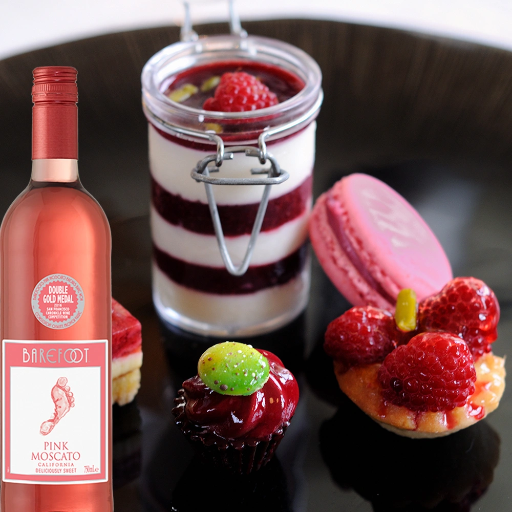 Barefoot Pink Moscato Roséwein mit Dessert und süßen Speisen auf einem Tisch angerichtet
