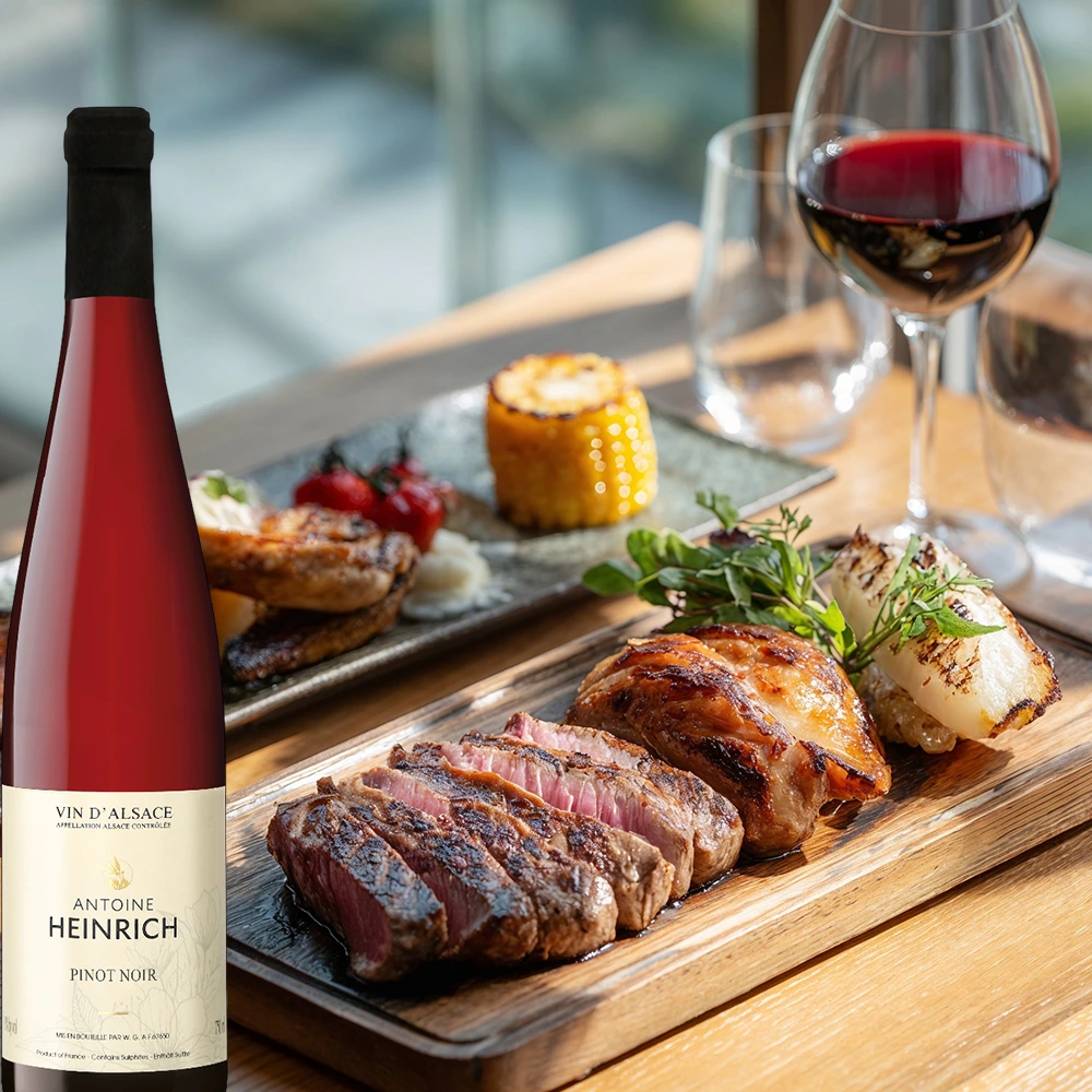 Antoine Heinrich Pinot Noir mit Steak und gegrilltem Gemüse auf einem gedeckten Tisch in rustikaler Atmosphäre