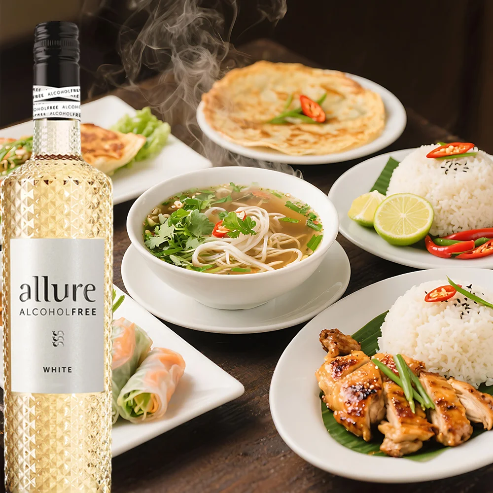 Flasche Allure Weiß alkoholfrei neben einer Auswahl asiatischer Gerichte auf einem Tisch, stilvoll angerichtet
