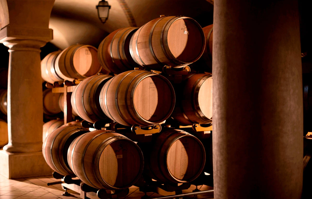 Weinfässer im Keller von Cà dei Frati, stimmungsvolles Licht- und Schattenspiel zwischen den Holzfässern während der Weinreifung