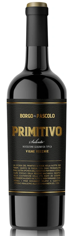 Flasche Borgo al Pascolo Primitivo Solo Rotwein auf einem romantisch gedeckten Tisch mit Steakgericht, im Hintergrund eine beleuchtete City Skyline bei Abendstimmung.