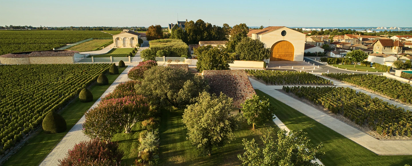 Luftaufnahme des Weinguts Baron Philippe de Rothschild in Bordeaux mit Gebäuden, Weinbergen und weitläufigen Parkanlagen in der Umgebung.