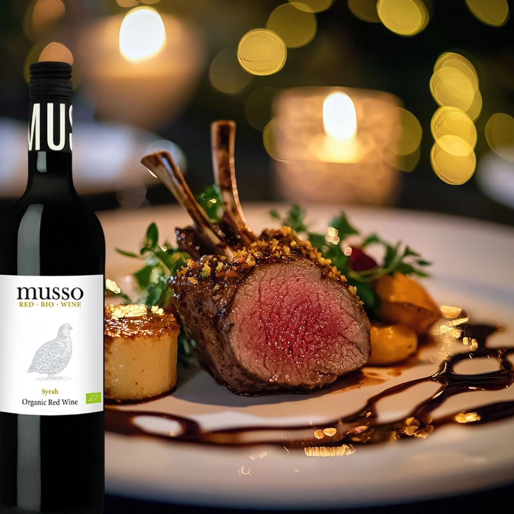 Musso Syrah Bio Rotwein auf festlich gedecktem Tisch mit Lammkarree elegant angerichtet