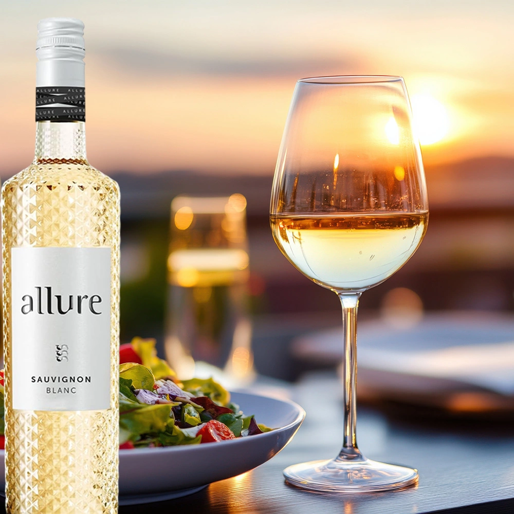 Flasche Sauvignon Blanc auf einem Tisch neben einem Salatteller, im Hintergrund Sonnenuntergang, stimmungsvolle Atmosphäre