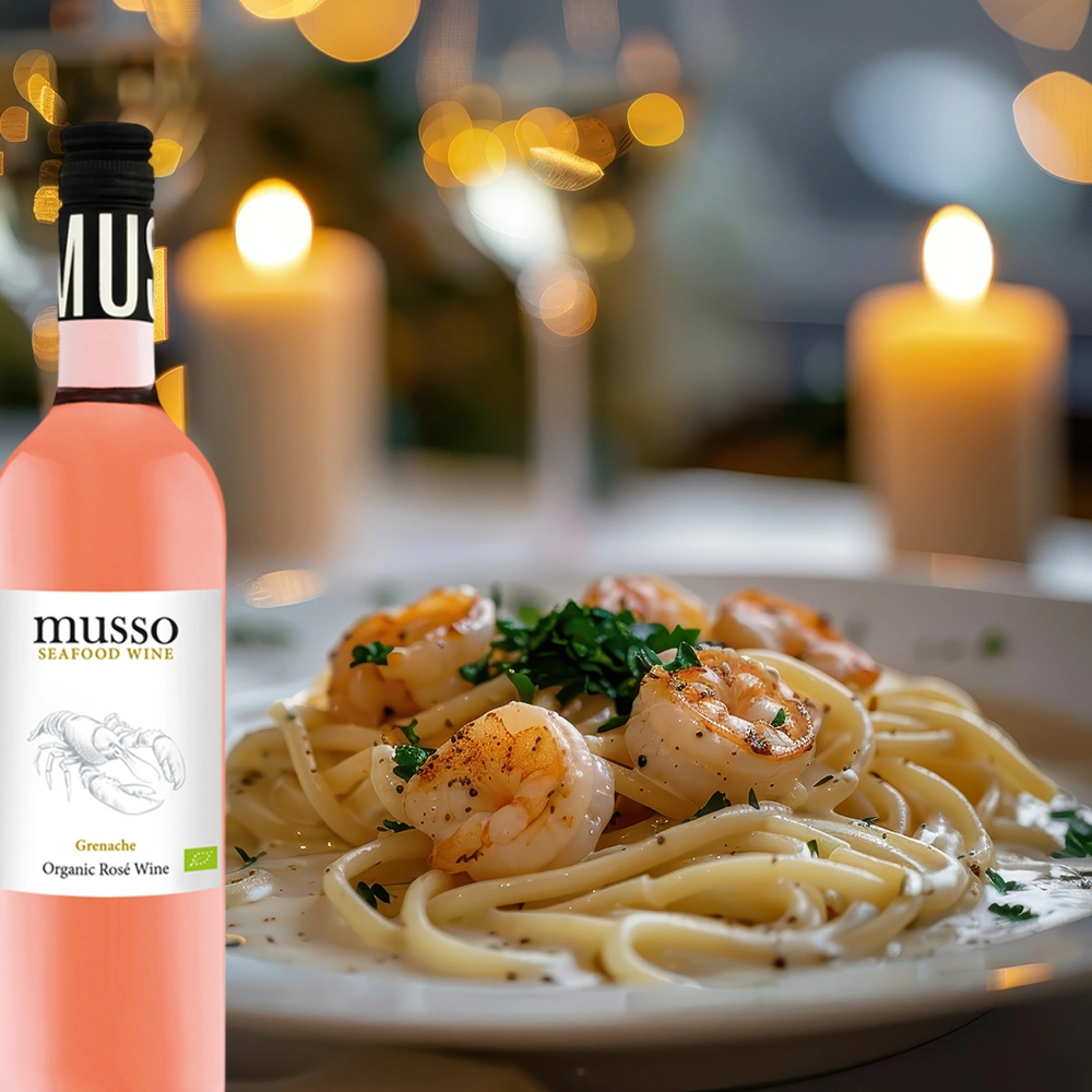 Musso Grenache Bio Roséwein mit Pasta und Shrimps auf festlich gedecktem Tisch bei romantischem Kerzenschein