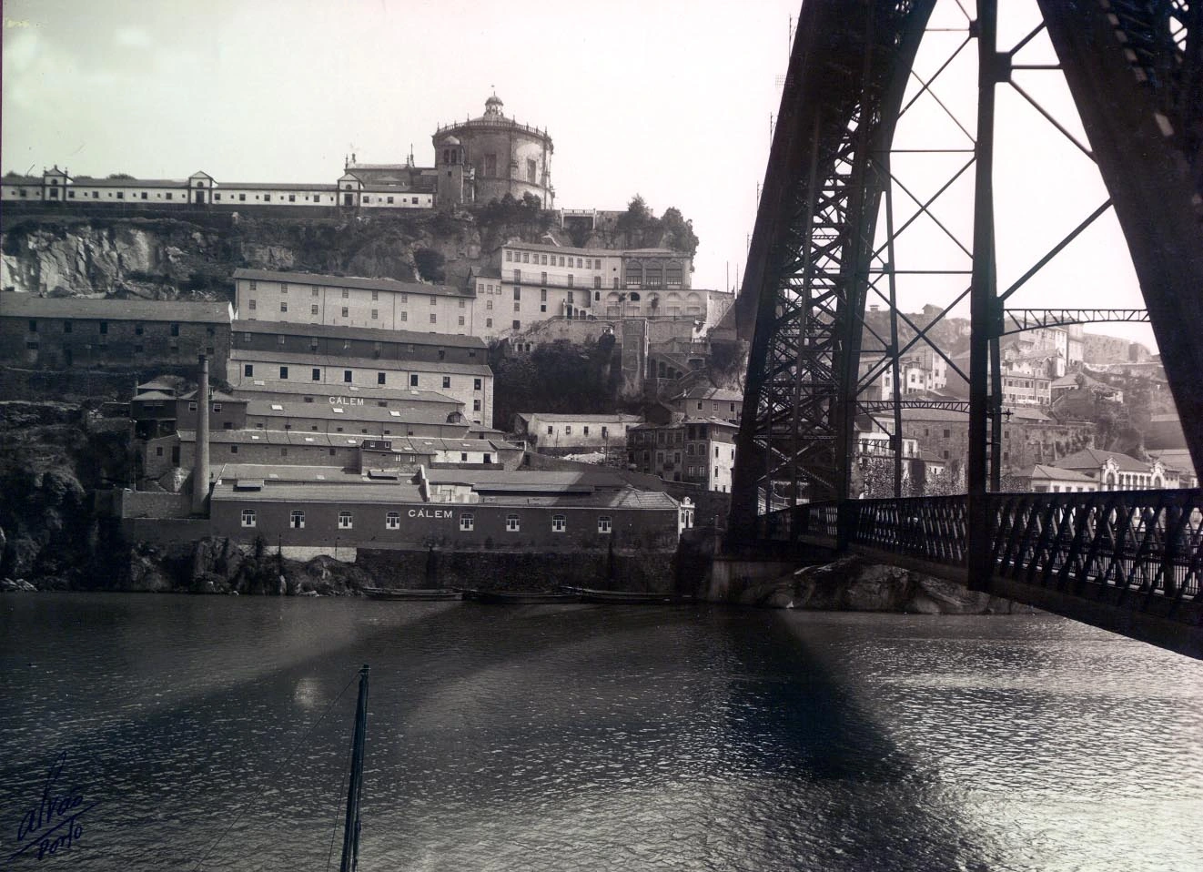 Historische Aufnahme des Cálem Gebäudes am Fluss in Porto mit Brücke