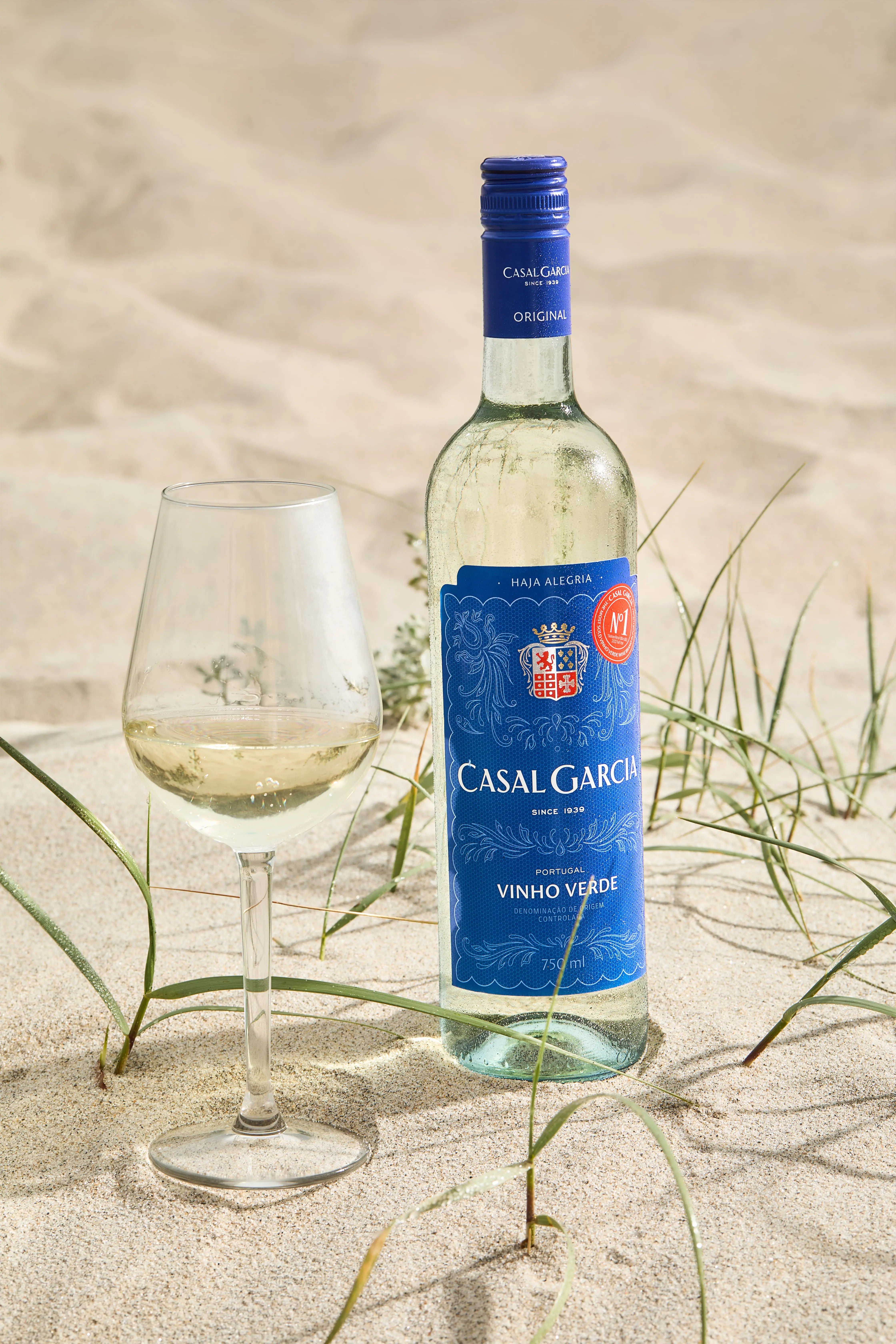 Casal Garcia Vinho Verde Weißwein am Strand im Sand stehend neben einem gefüllten Weinglas bei sommerlicher Atmosphäre