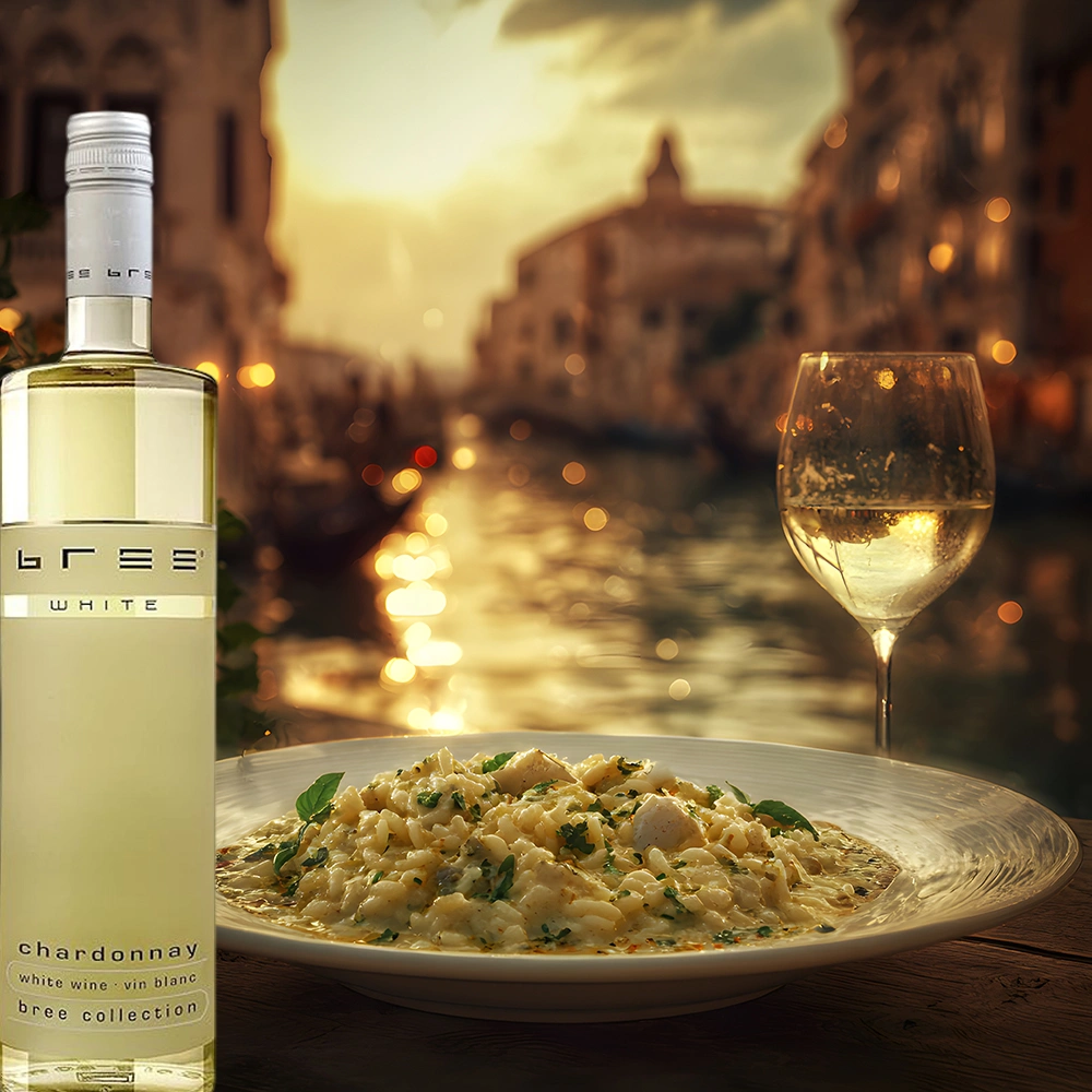 Bree Chardonnay Weinflasche mit cremigem Risotto auf einem stilvoll gedeckten Tisch in einer romantisch beleuchteten Gasse am Wasser mit vorbeiziehenden Gondeln als elegante Weinbegleitung
