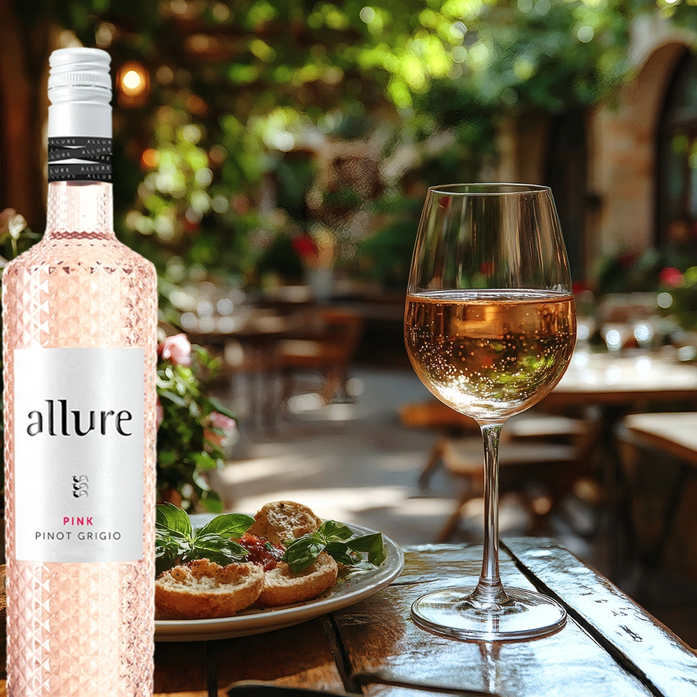 Flasche Allure Pinot Grigio Pink neben einem Teller Bruschetta, im Hintergrund ein mediterraner Garten