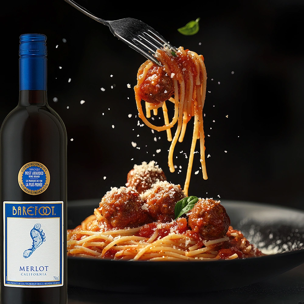 Barefoot Merlot Rotwein mit Pasta, Fleischbällchen und geriebenem Parmesan auf rustikalem Tisch