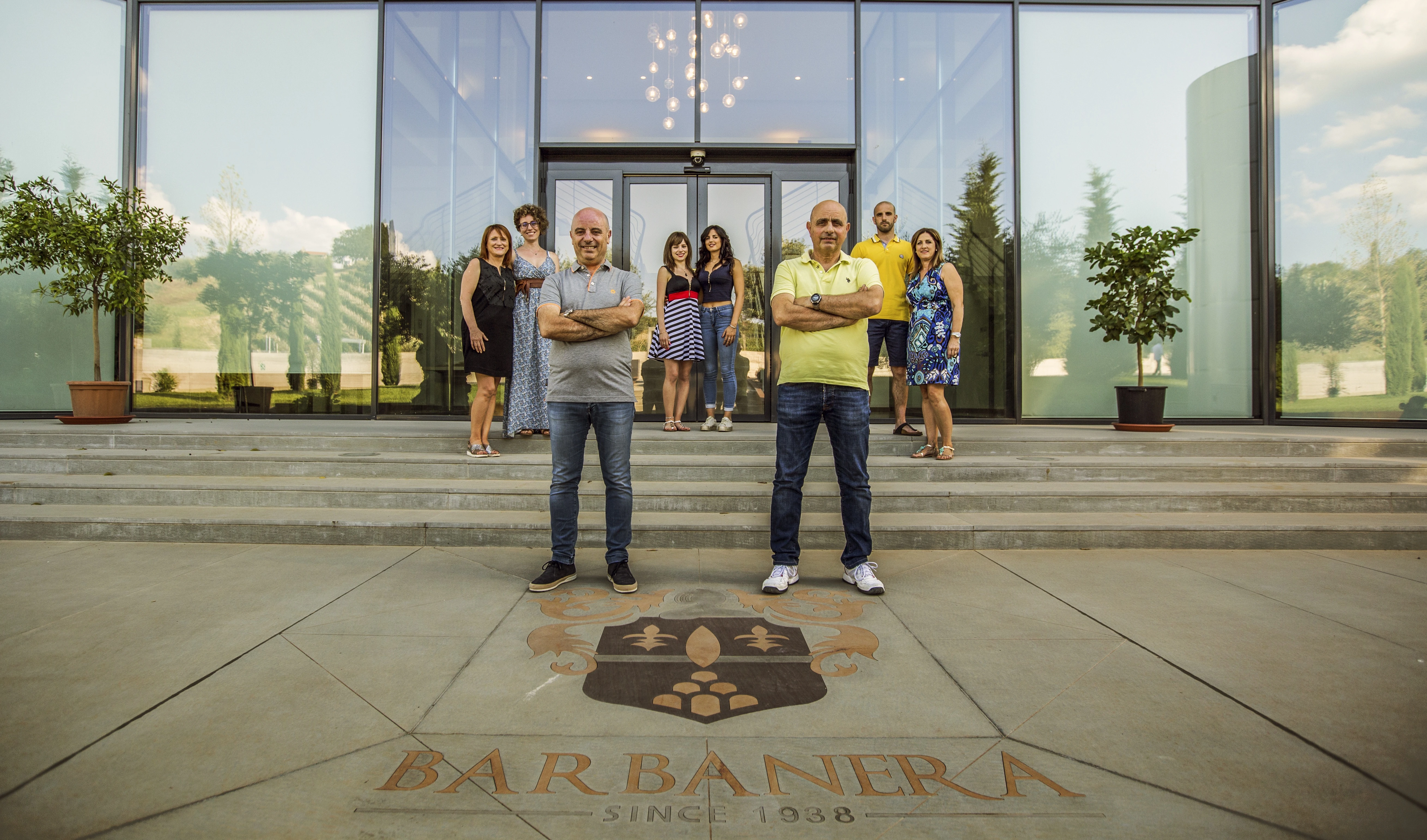 Inhaberfamilie des Weinguts Barbanera vor dem Gebäude in der Toskana mit Barbanera Schriftzug im Vordergrund