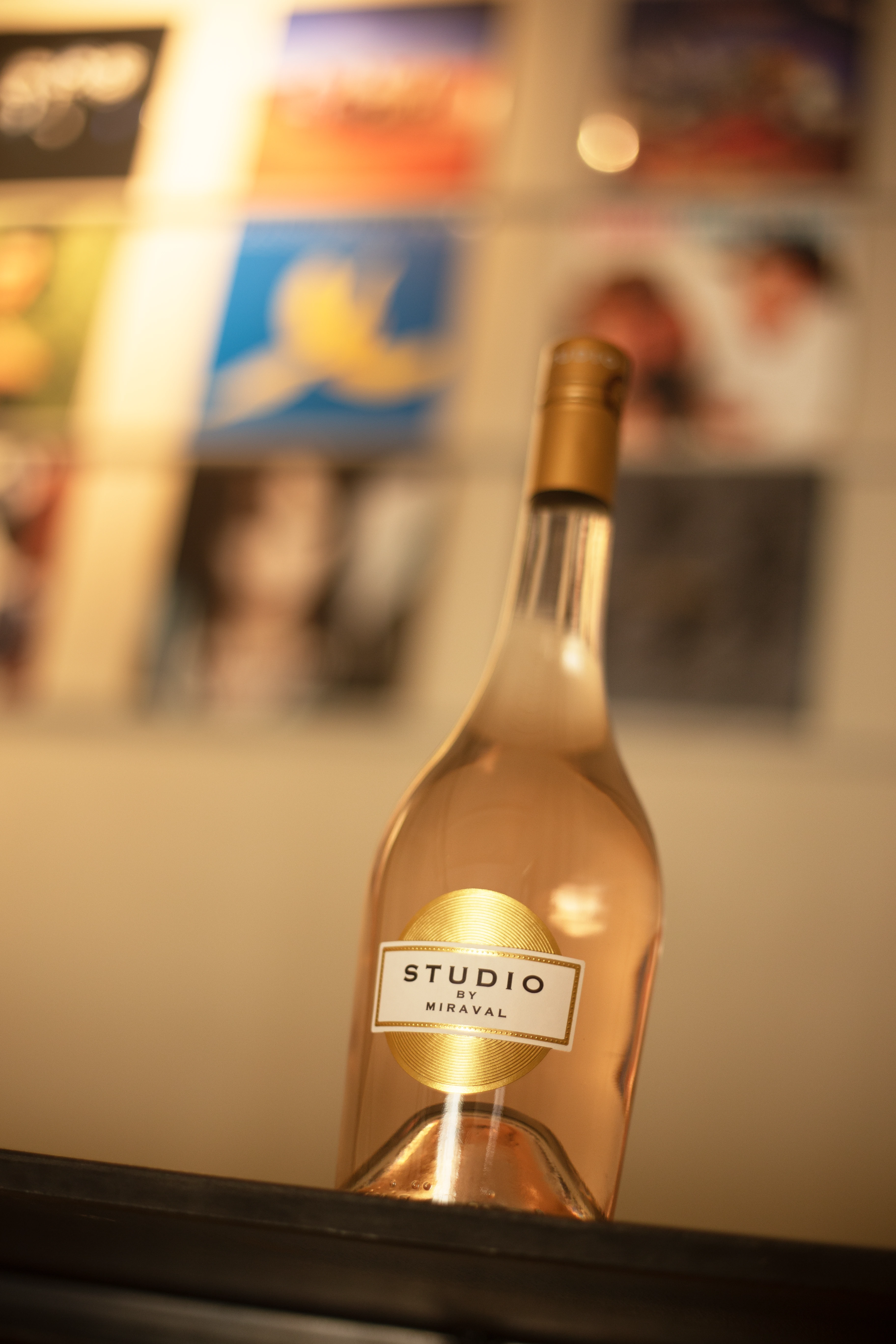 Studio Miraval Rosé von unten fotografiert mit verschwommenen Gemälden im Hintergrund