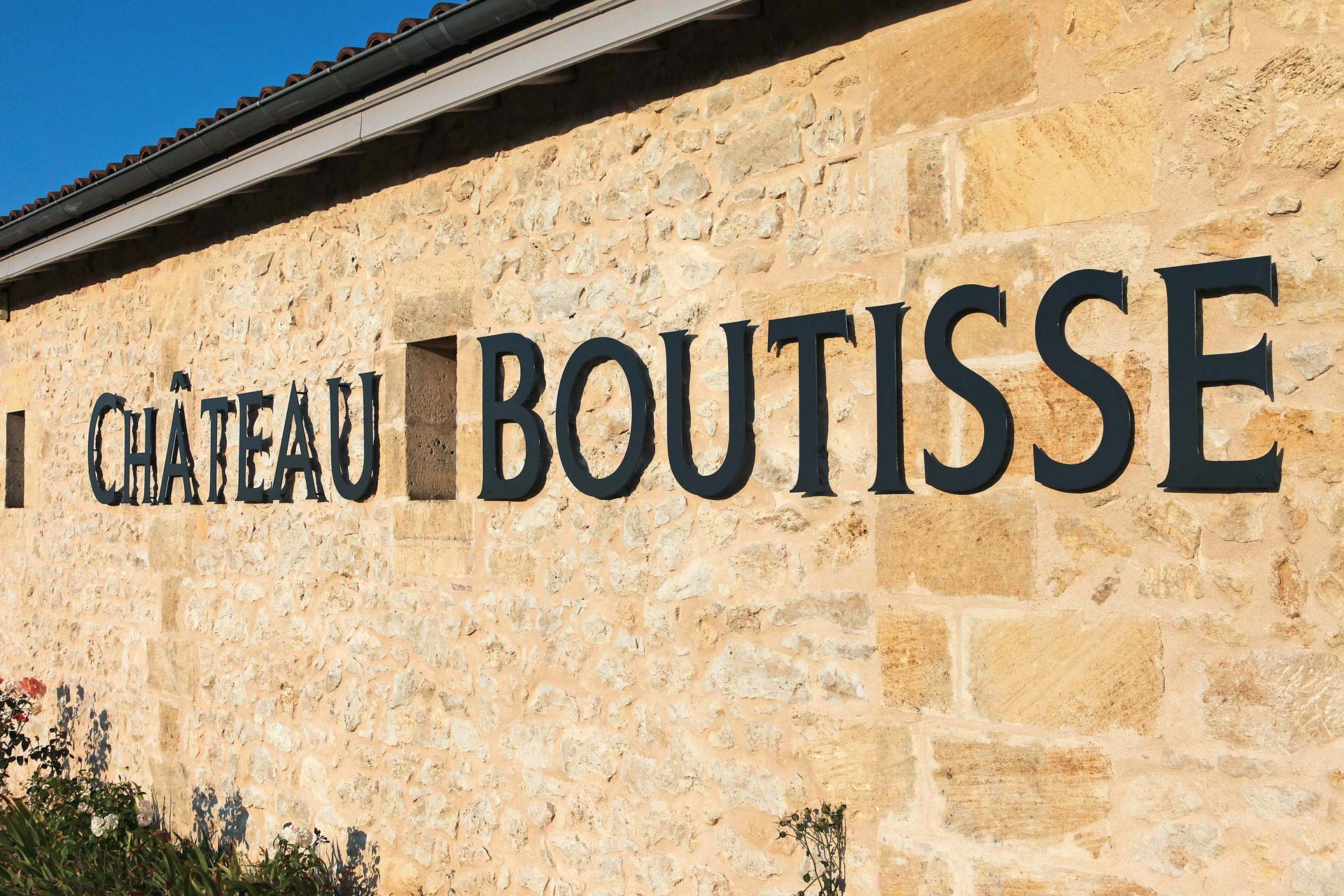 Eingangspforte von Château Boutisse mit eingraviertem Schriftzug auf Naturstein
