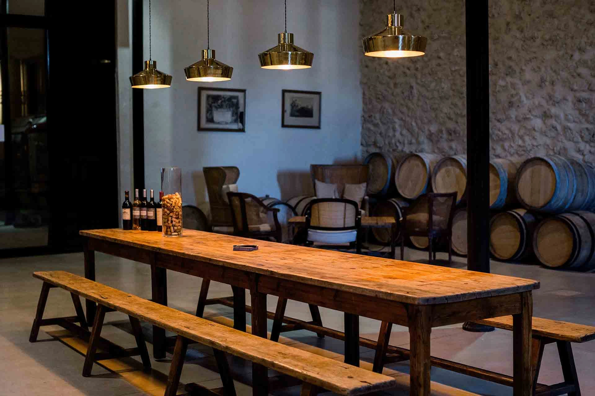 Stimmungsvolles Restaurant bei Bonfils mit langer gedeckter Tafel, Holzbänken und Weinfässern im Hintergrund