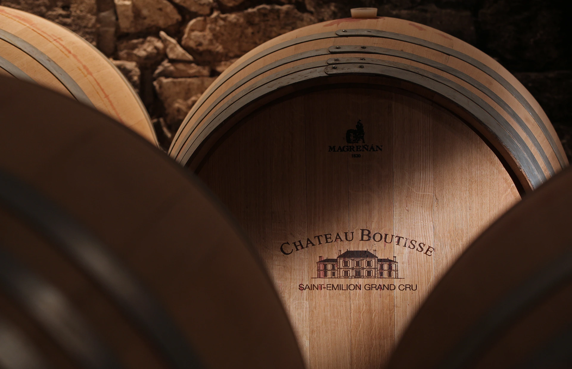 Weinfässer im historischen Natursteinkeller von Château Boutisse in Saint-Émilion