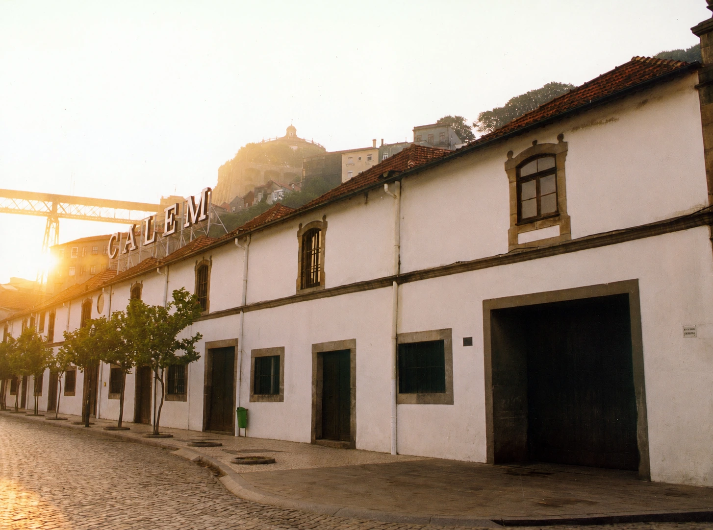 Historisches Cálem Gebäude bei Sonnenuntergang mit beleuchtetem Schriftzug über dem Gebäude