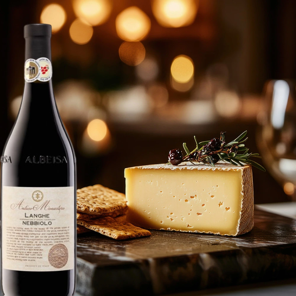 Flasche Antico Monastero Langhe Nebbiolo auf einem Tisch mit einer Käseplatte und Crackern, umgeben von Kerzenschein