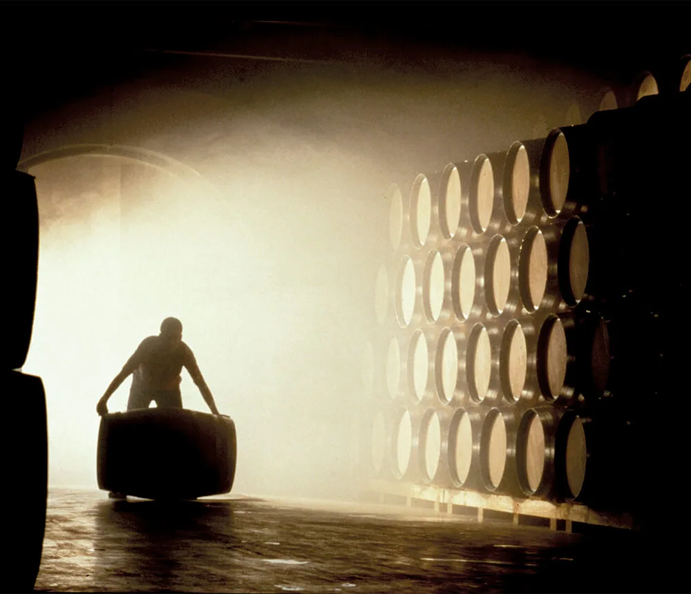Mann rollt Weinfass durch das Weinlager der Bodegas Ondarre in der Rioja